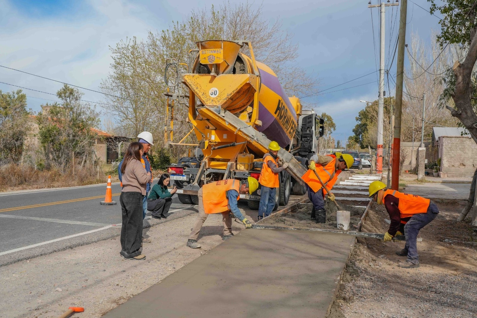Trabajadores municipales construyen una vereda sobre calle Benavidez en El Mogote, Chimbas