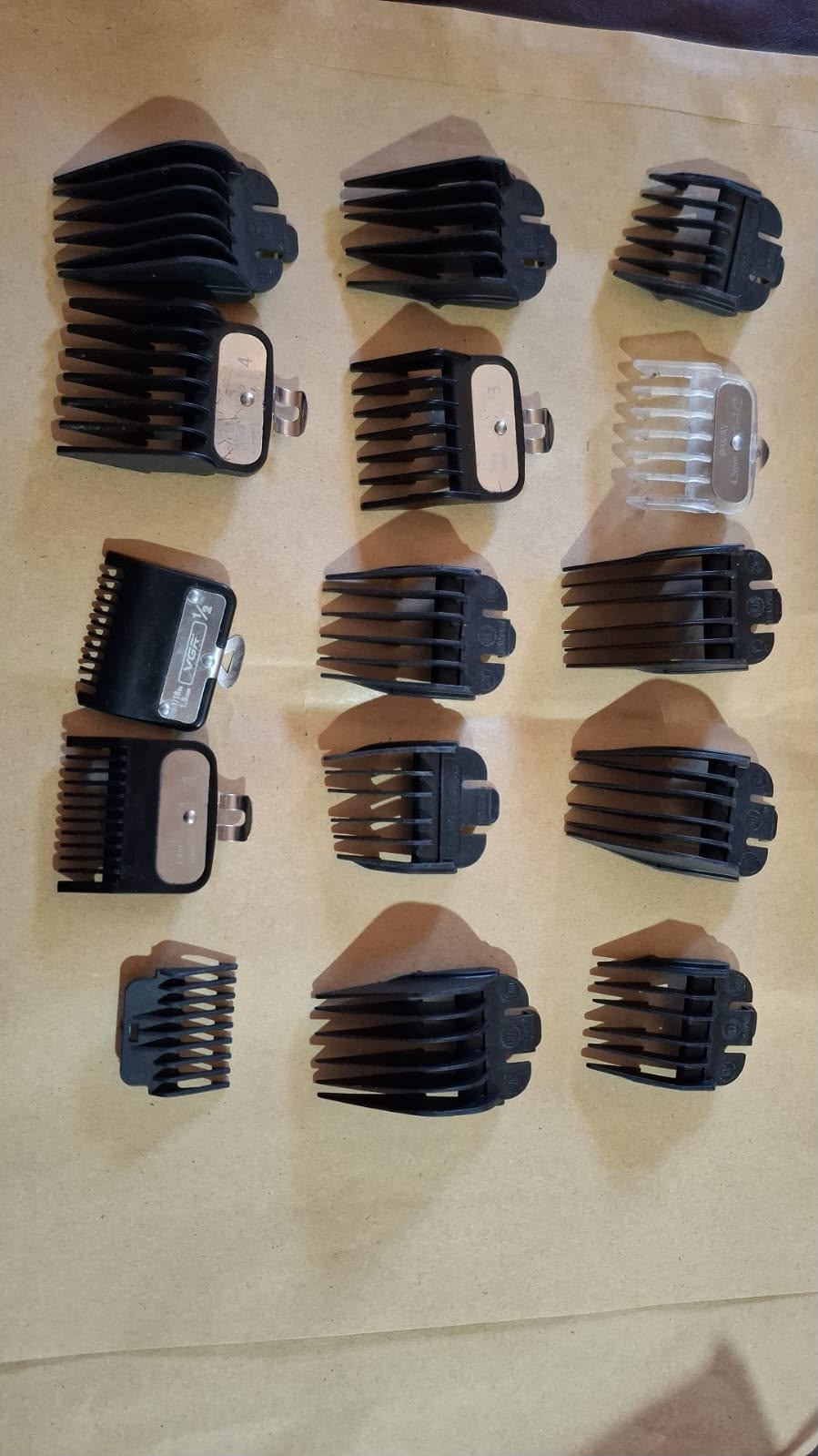 Peines y accesorios para máquinas de cortar pelo dispuestos sobre una superficie.