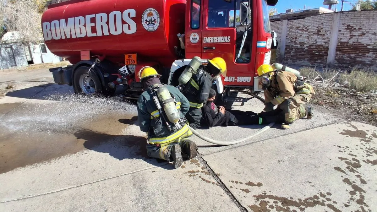 Bomberos con equipos de protección junto a un camión en una fotografía de archivo