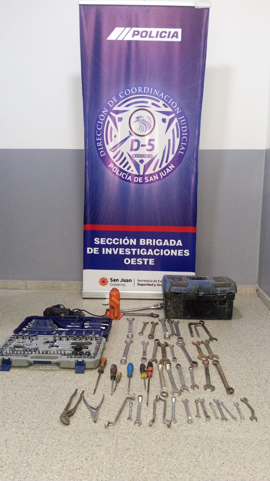 Herramientas recuperadas: maletín de bocallaves, caja de herramientas, gato hidráulico y llaves de distintas medidas, frente al cartel de la Brigada de Investigaciones Oeste de la Policía de San Juan.