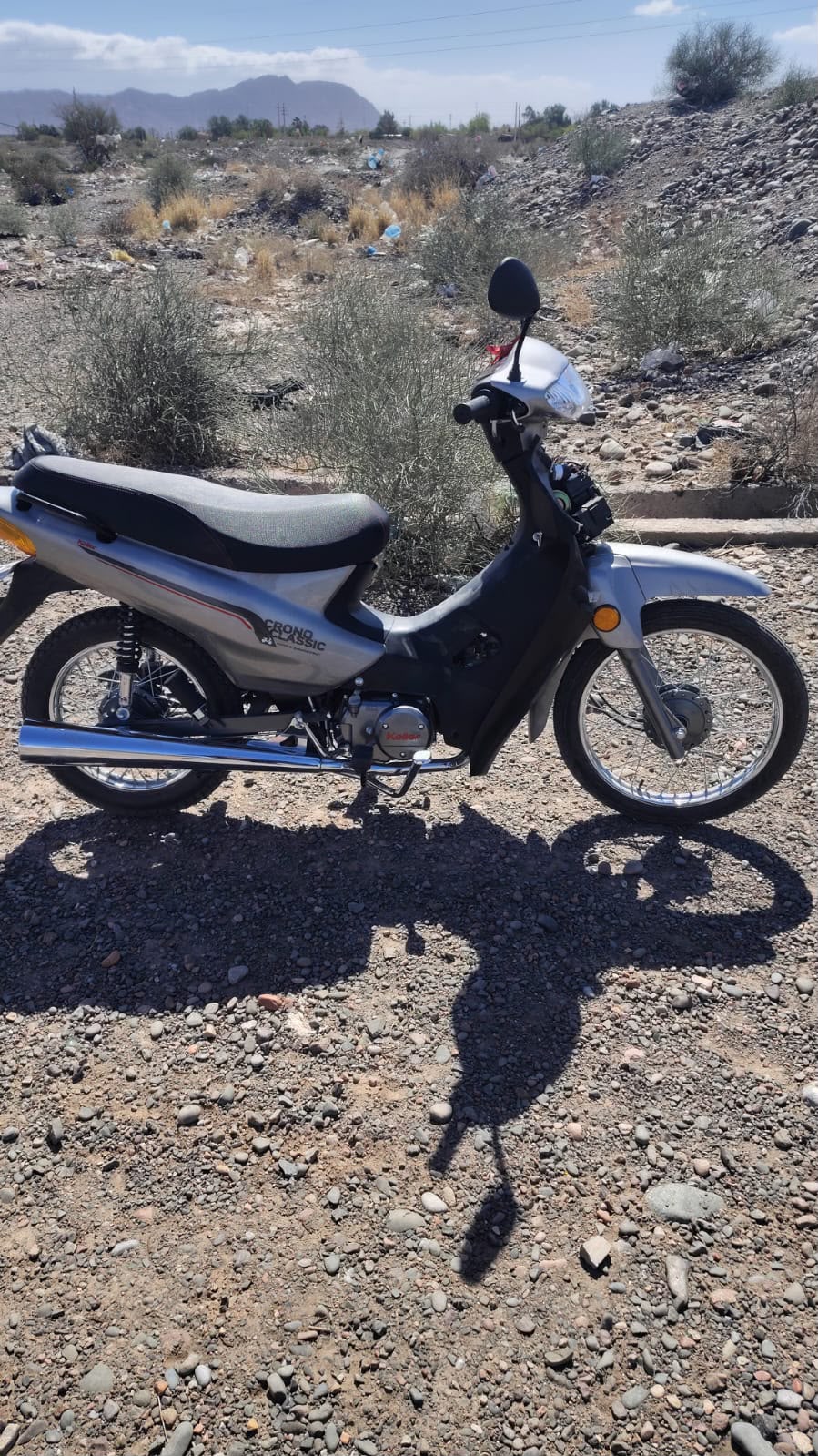 Motocicleta Keller gris recuperada en un descampado de Barrio Nuevo Cuyo, con parte del frente desmontado y el circuito eléctrico expuesto.
