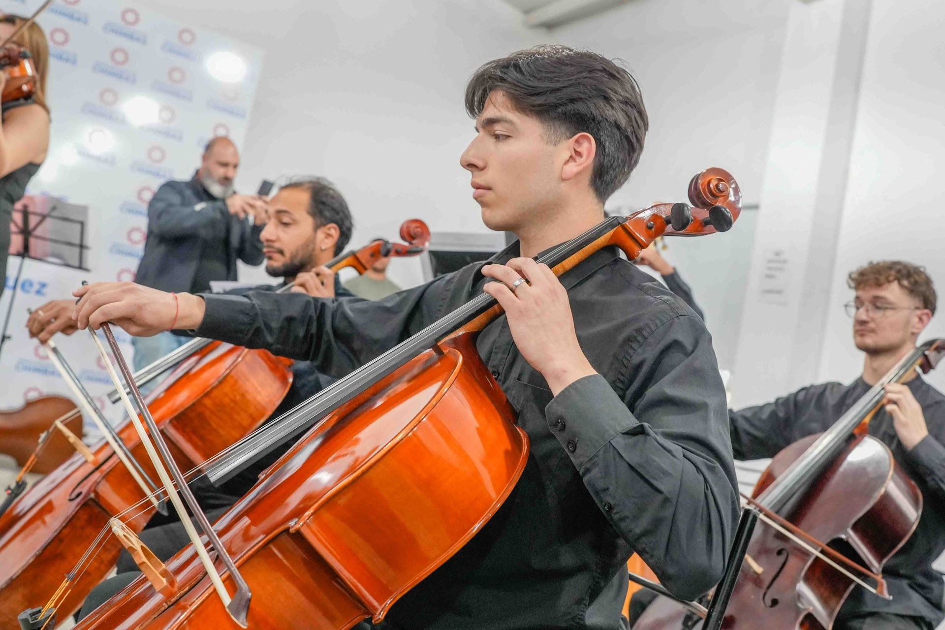 Músicos interpretan violonchelos durante el concierto.