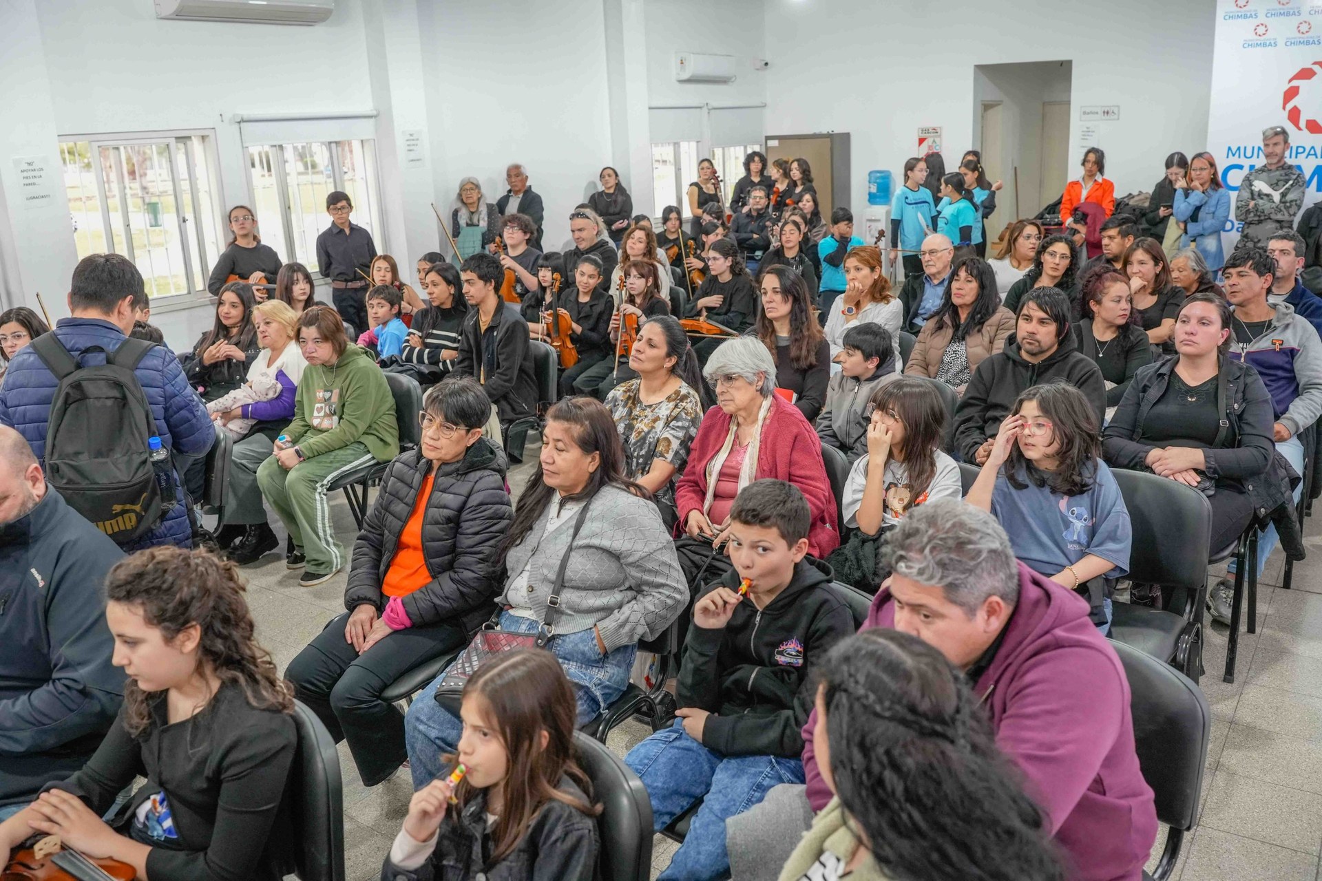 Familias y vecinos acompañan el concierto en el Salón Cultural Sur.