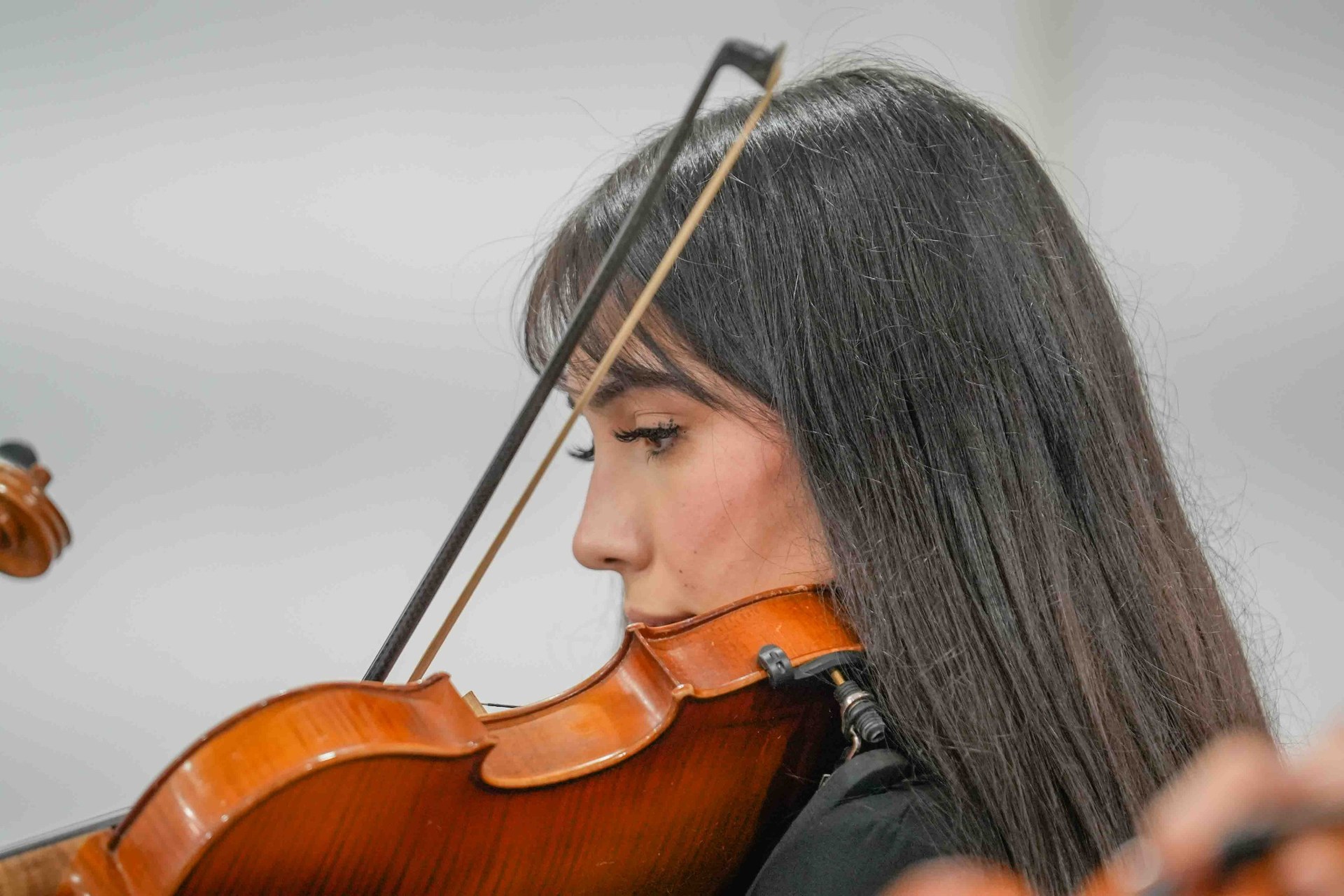 Una joven interpreta el violín en el concierto de las orquestas.