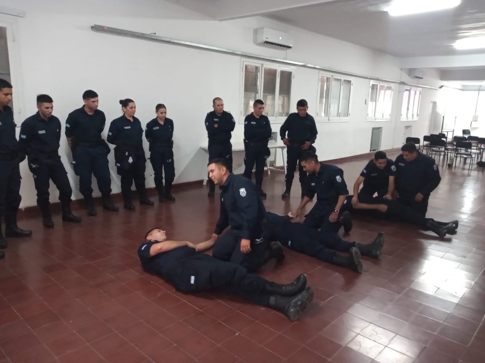 Personal policial participa en una práctica de primeros auxilios durante una capacitación.