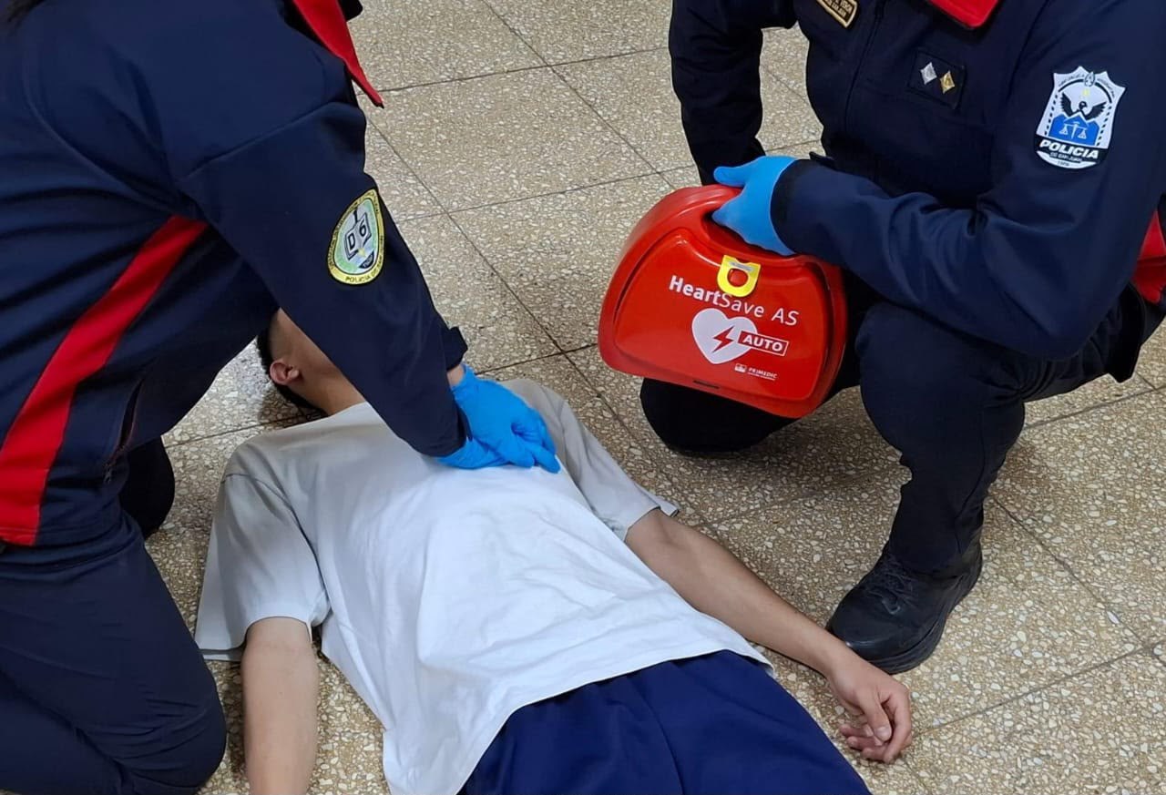 Demostración de asistencia con personal policial y un equipo desfibrilador.
