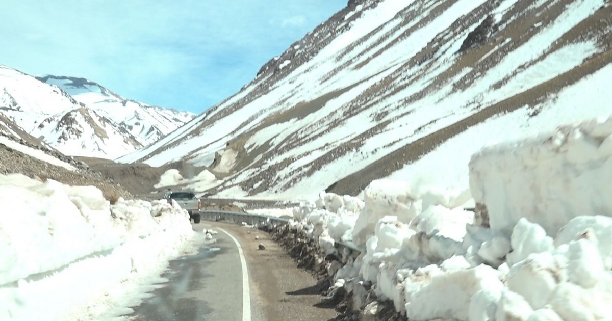 Camino cordillerano con nieve acumulada a ambos lados de la calzada.