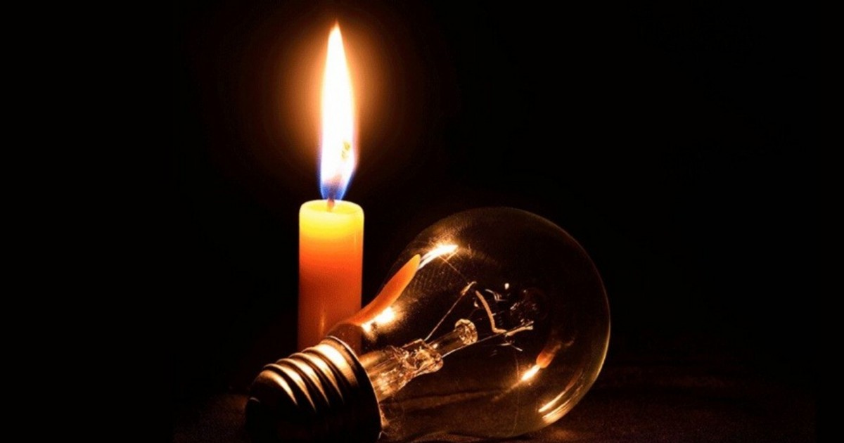 Fotografía de una vela encendida junto a una lámpara apagada.