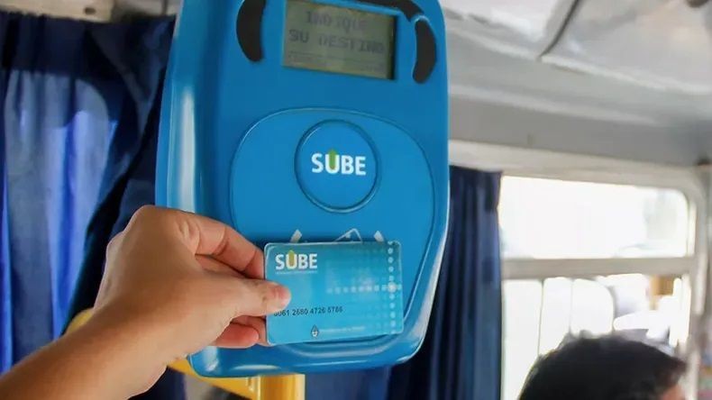Una persona acerca una tarjeta SUBE al lector de un colectivo.