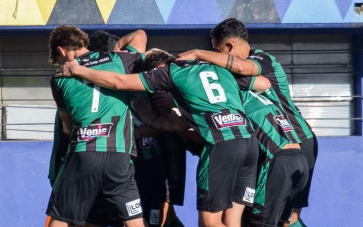Jugadores de San Martín con camisetas verdes y negras abrazados durante un festejo