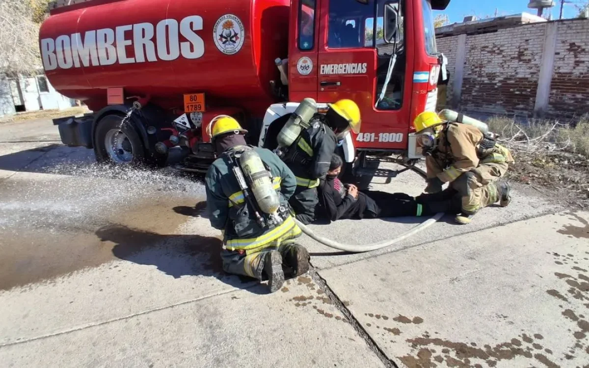 Bomberos con equipos de protección junto a un camión en una fotografía de archivo
