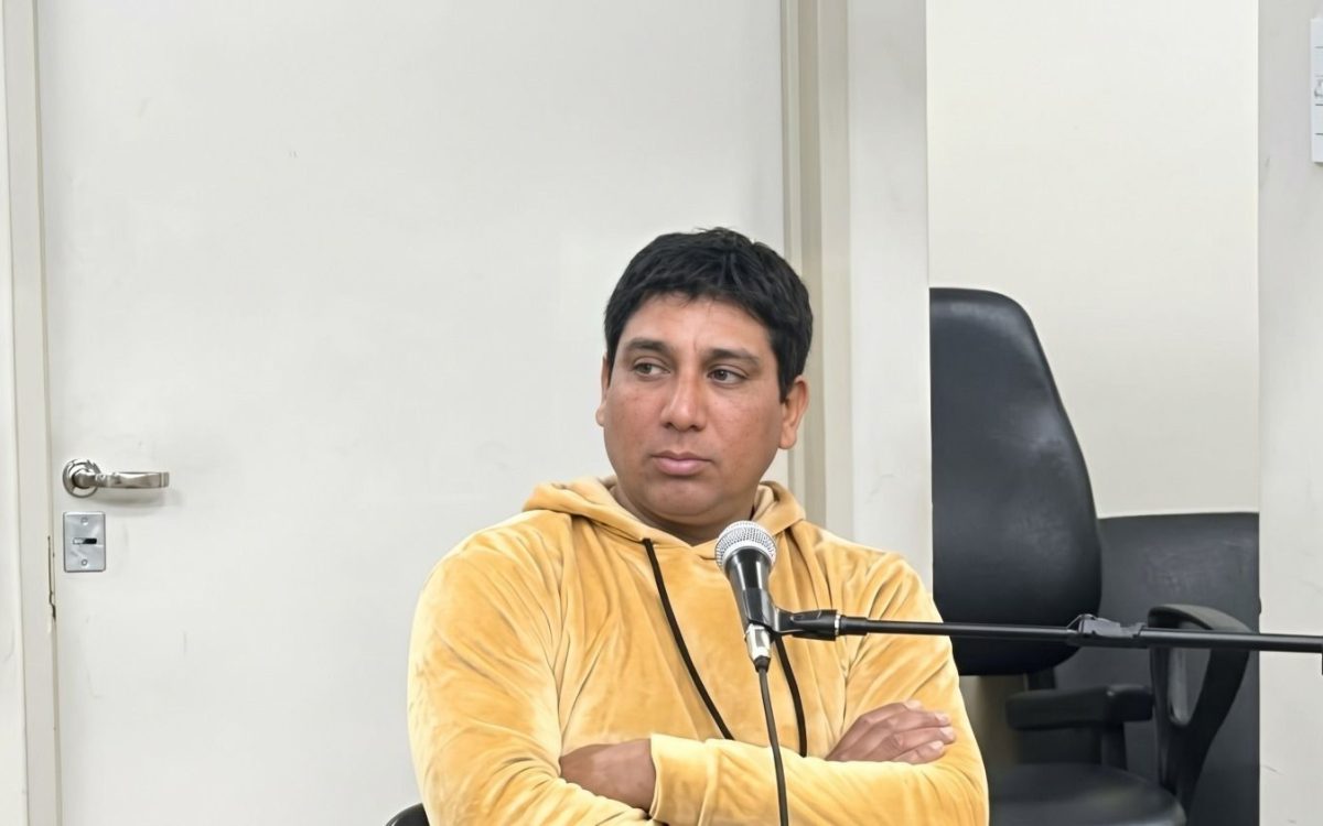 Facundo Nievas, sentado con los brazos cruzados frente a un micrófono durante una audiencia