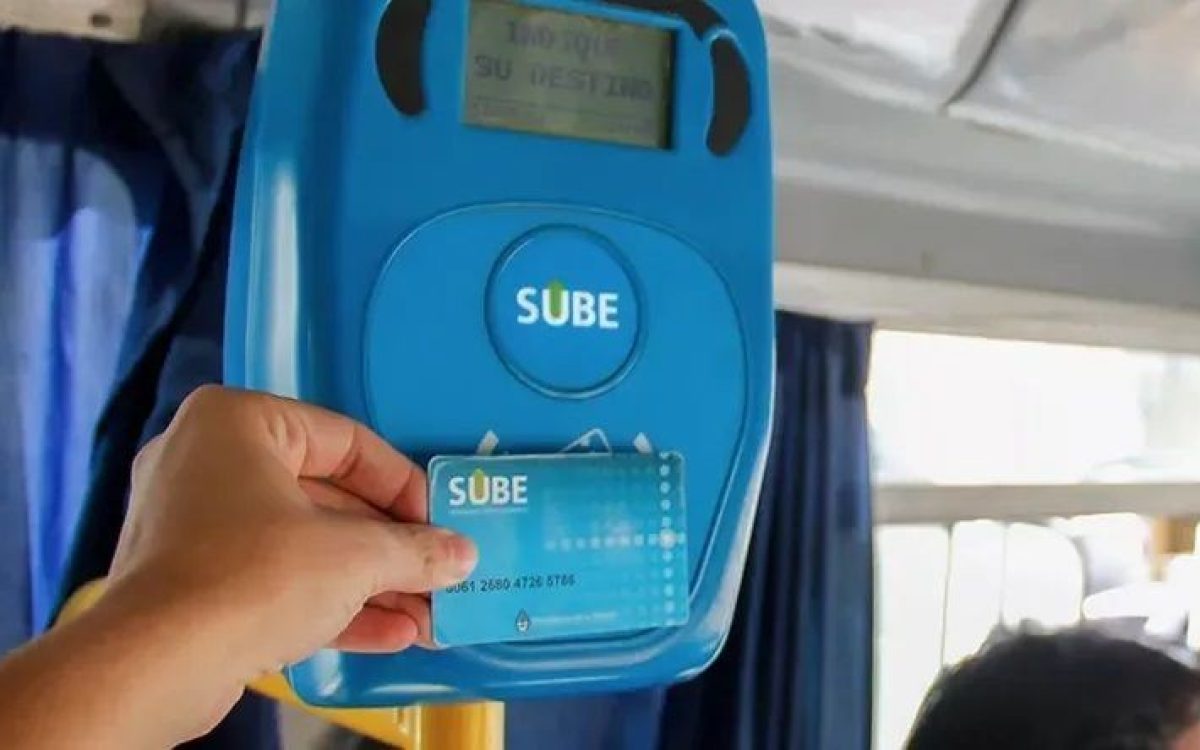 Una persona acerca una tarjeta SUBE al lector de un colectivo.