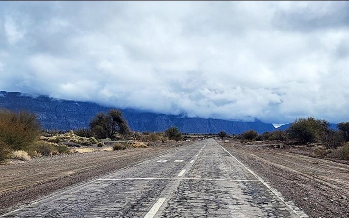 Calzada deteriorada de la Ruta 40 Norte, con montañas al fondo.