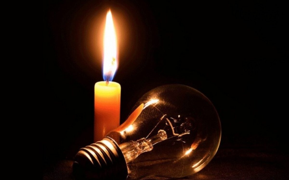 Fotografía de una vela encendida junto a una lámpara apagada.
